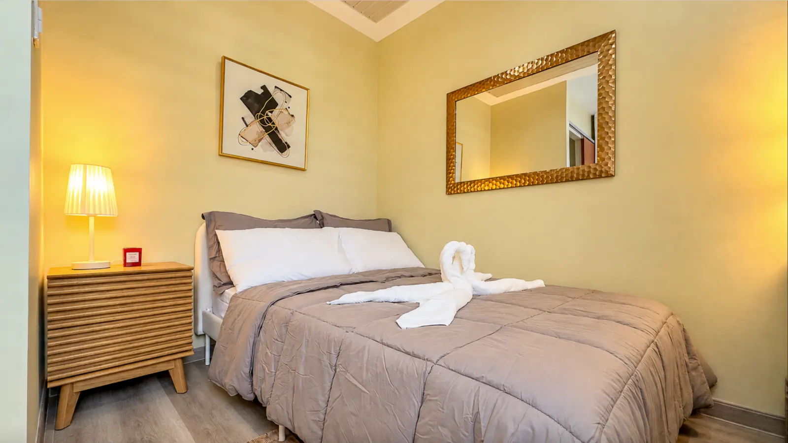 Bedroom 1 with double bed, mirror and bedside lamp